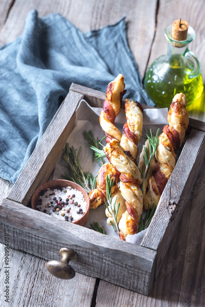 Poster Bacon-wrapped breadsticks on the wooden tray