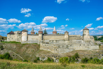Fototapeta na wymiar Photo of ancient stone castle with many hight towers in Kamyanets-Podilsky