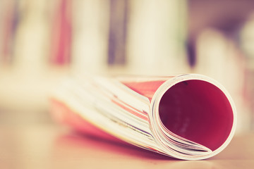 Close up edge of colorful magazine stacking roll with  blurry bookshelf background for bublication...