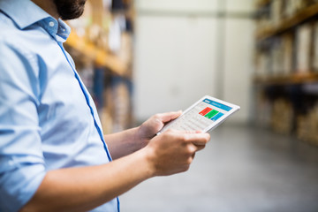 Man warehouse worker with a tablet.