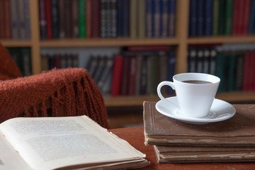Sweet moments of relaxation with books and a cup of coffee. Vintage books, glasses, chair, library