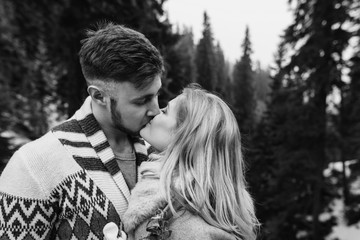 Man hugging woman on wooden bridge in mountain