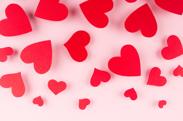 Paper red hearts falling on soft pink color background. Valentine day concept for design.