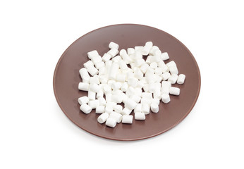 Fototapeta na wymiar White marshmallow on a brown dish