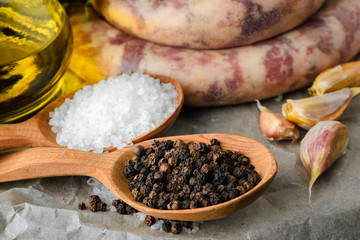 salt and pepper, homemade sausages and garlic on the table