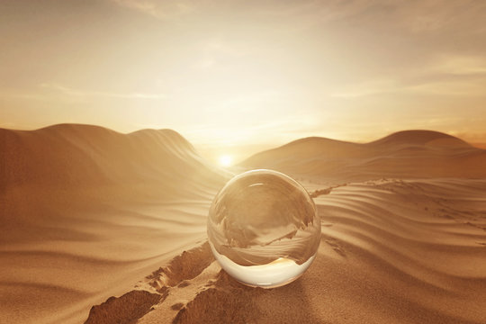 3d rendering of crystal ball on desert landscape with footsteps in the evening sunlight