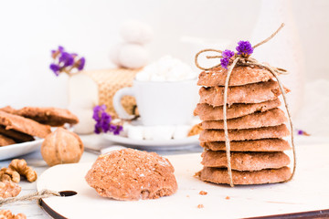 Homemade chocolate chip cookies with walnuts on the kitchen board. Table setting for breakfast