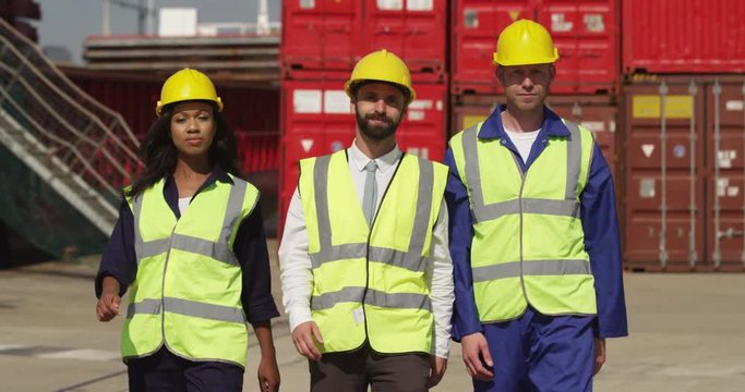 Portrait of dock workers at an industrial harbor walking towards the camera. Shot on RED Epic.