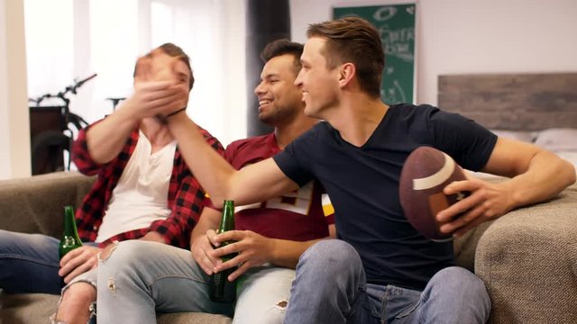 Football fans with beer at living room 