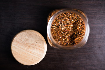 Cayenne pepper in a glass on wood background.