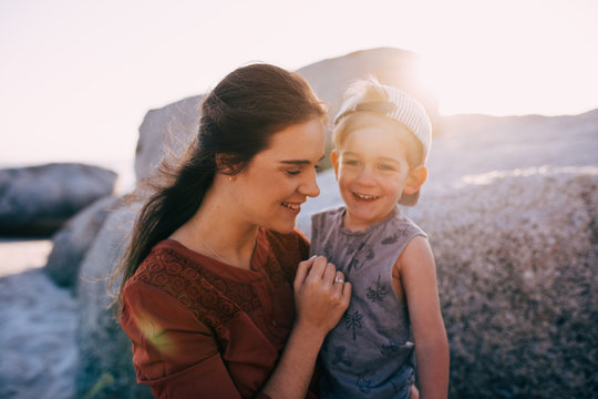 Happy mother and little boy smiling at the beach