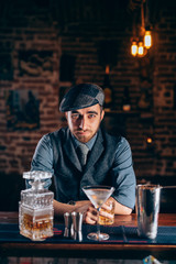 Vintage man enjoying a relaxing old fashioned drink at bar.