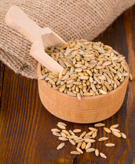 raw rye in a Cup with spoon  on a wooden table.