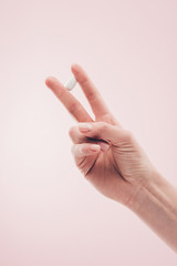 partial view of woman holding medicine in hand isolated on pink