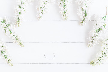 Flowers composition. Frame made of white lilac flowers on white wooden background. Flat lay, top view, copy space