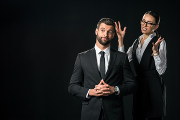 angry female boss quarreling at businessman, isolated on black