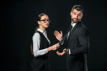 businesspeople holding knife and quarreling isolated on black