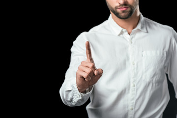 cropped view of businessman pointing up, isolated on black