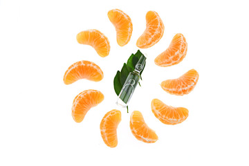 Vitamin C. Transparent glass ampoule with vitamin C on mandarin leaves and slices of fresh manarin on a white background. Health and Beauty	