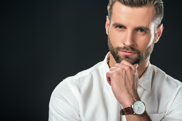 portrait of handsome pensive businessman in white shirt, isolated on black