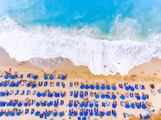 Bird's-eye view of a beach with big waves, sunbeds and umbrellas in Lefkada, Greece