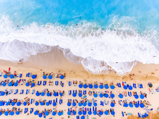 Birds eye view of a beach with big waves, sunbeds and umbrellas in Lefkada, Greece