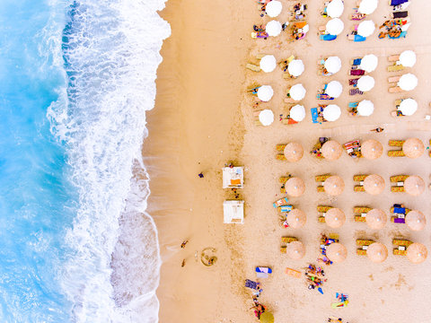 Sunbeds and umbrellas bird's eye view on sand beach in Greece