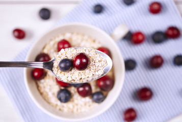 Porridge with fruit on spoon .