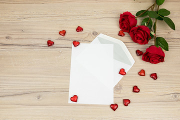 Valentines Day, Red roses with a blank invitation card and red hearts on wooden background, decoration for 
Valentines Day, wedding day concept