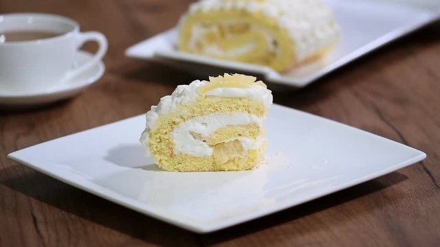 A woman eats a piece sweet pineapple roll cake