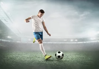 Tuinposter Soccer player on a football field in dynamic action at summer da © Andrii IURLOV