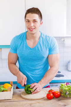 Essen zubereiten Gemüse schneiden junger Mann Mittagessen in der Küche Hochformat gesunde Ernährung