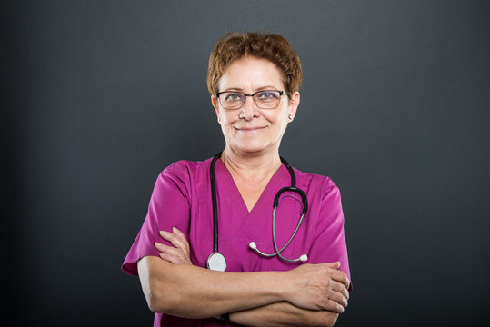 Portrait of senior lady doctor standing with arms crossed