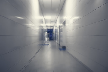 Long corridor with white tiles in industrial factory. Motion blur