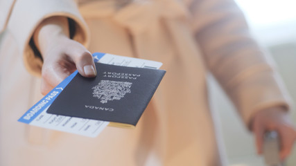 Girl holds Canadian passport and boarding passort