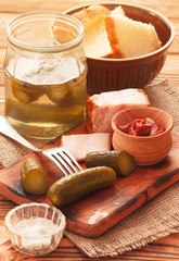 Vertical salty preserved cucumbers with tomato sauce and pork bacon