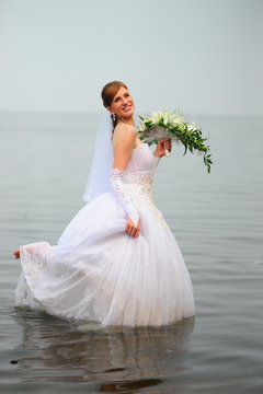 bride in wedding dress in water