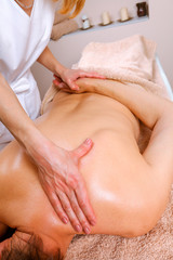 Obraz na płótnie Canvas Massage therapist massaging shoulders and back of a male