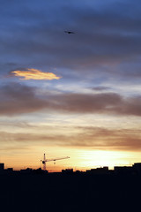 Fototapeta na wymiar Building crane and houses at sunrise.