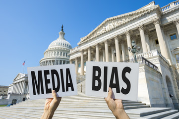 Hands of protestors holding up signs calling attention to media bias in Washington, DC, USA