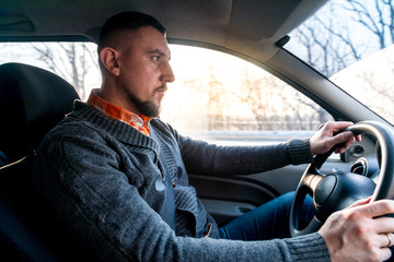 a man drives a car in the winter road in conditions of ice