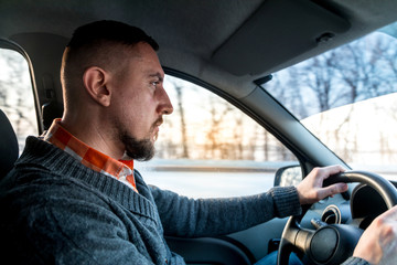 job driver. man drives a car in the winter in conditions of ice