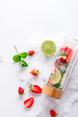 Drink with ice, berries, citrus and mint. Detox. Strawberry., lime. Mojito in a glass bottle.Food or Healthy diet concept.Super Food.Vegetarian.Copy space for Text.selective focus.