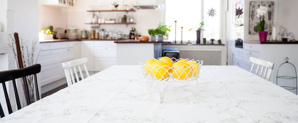 banner with lemons on the table with kitchen unfocused in teh background