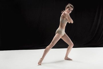 Young teen dancer on white floor background.