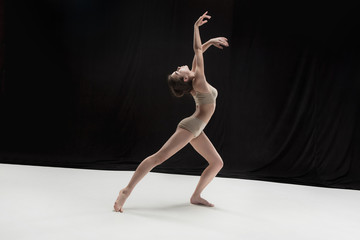 Young teen dancer on white floor background.