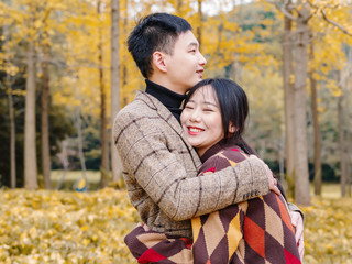 Chinese young man and woman together with emotional expression against autumn forest background, lover concept.