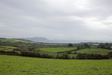 Fototapeta premium An agricultural scene with a backdrop of mountains and sea