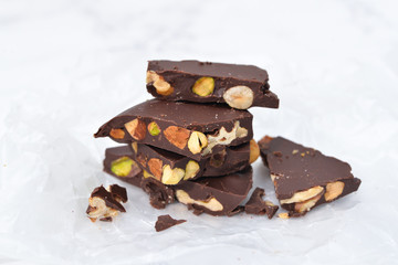 Dark chocolate bark with mixed nuts on wax paper