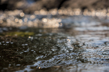 Close up.Flowing water with a bokeh sunlight background.